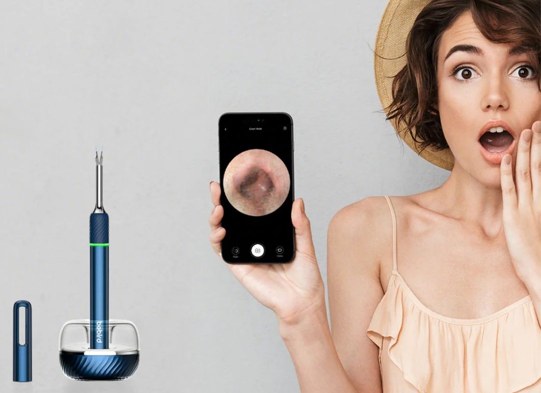 Frau reinigt ihre Ohren mit einem Ohrkamera-Reinigungswerkzeug