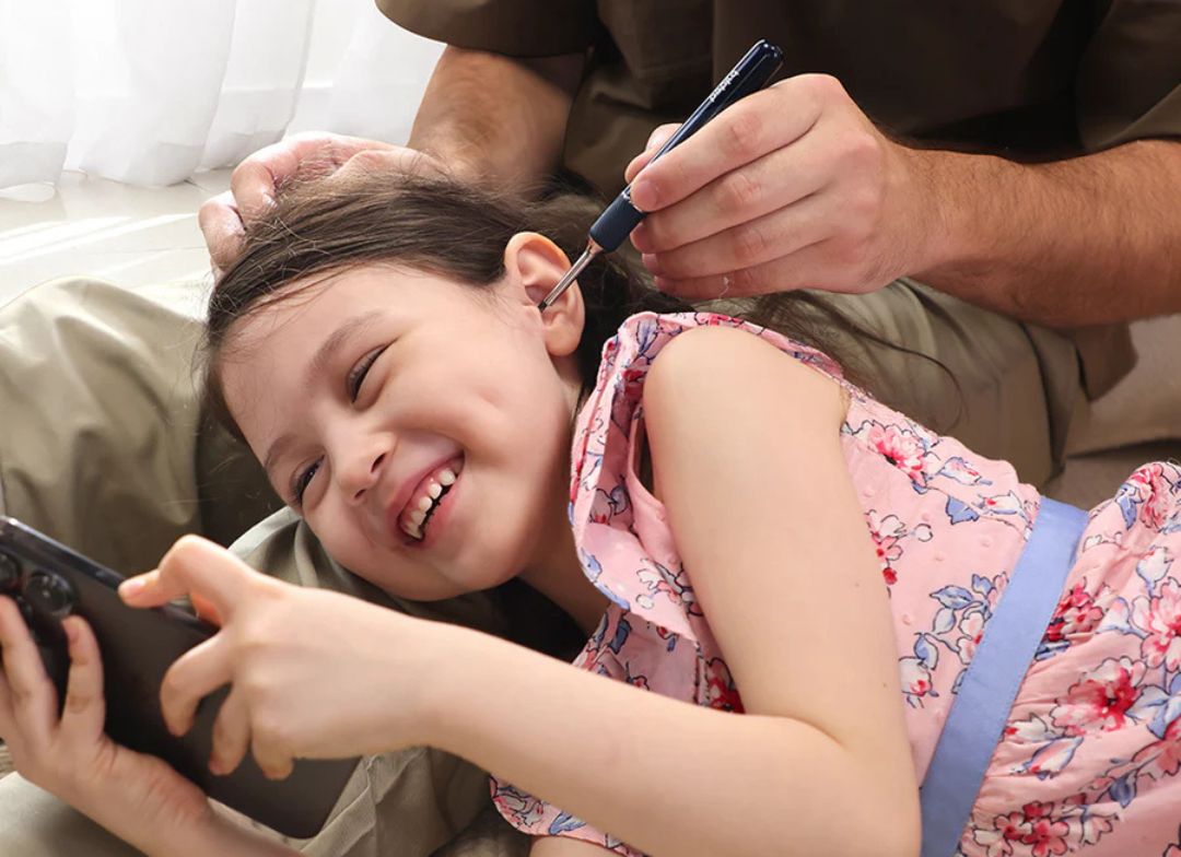 Dad cleaning his daughter's ears