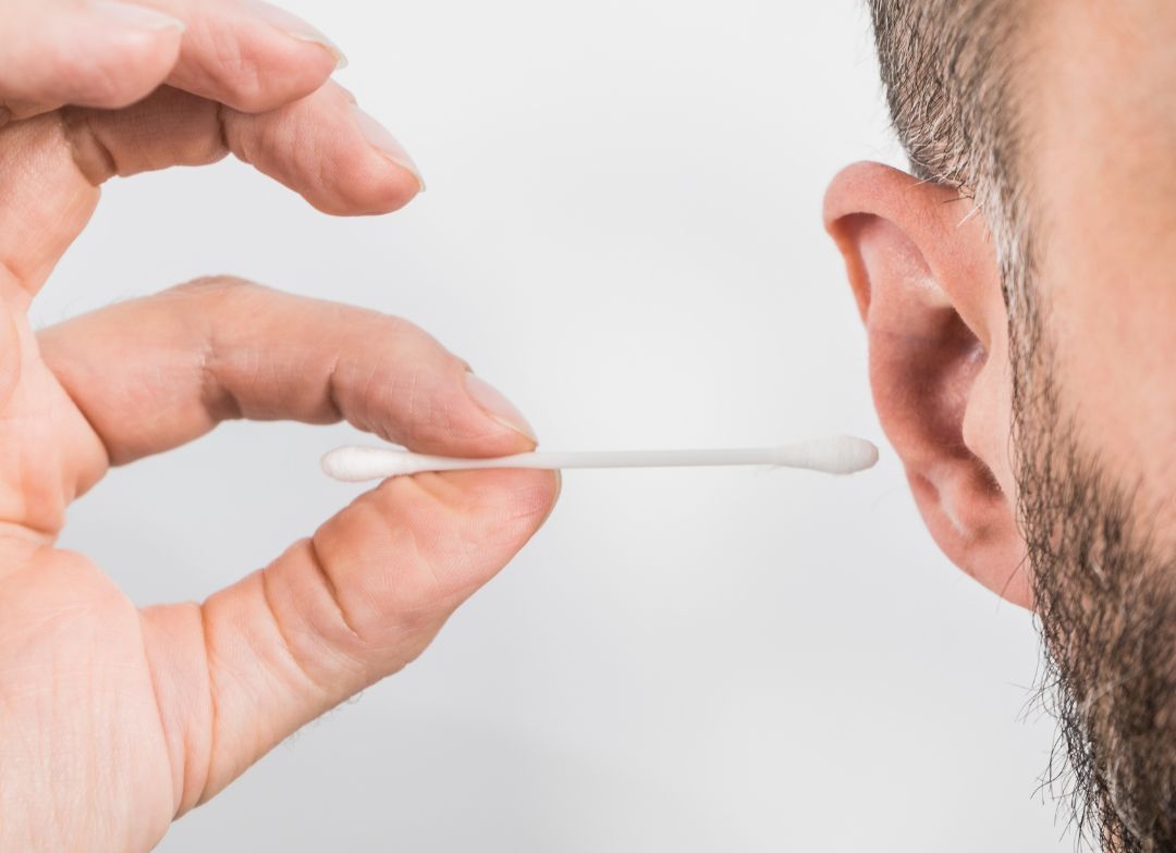 Cleaning the ears with a cotton swab